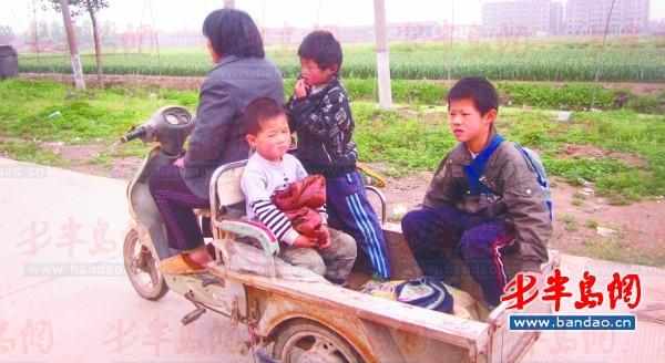 2011年底一名孩子在三輪車上趕作業(yè)。一年半過去了，這樣的場景仍隨處可見。