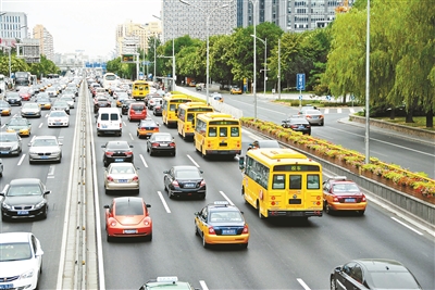 西二環主路，幾輛黃色校車列隊行駛供圖/CFP