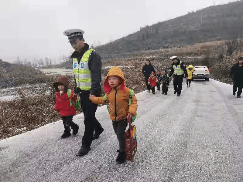 路面冰凍打滑校車(chē)受阻，警察“叔叔”牽著13個(gè)孩子回家