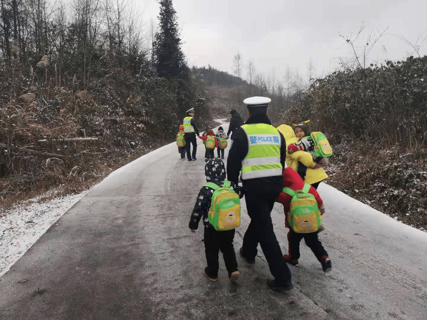 路面冰凍打滑校車(chē)受阻，警察“叔叔”牽著13個(gè)孩子回家